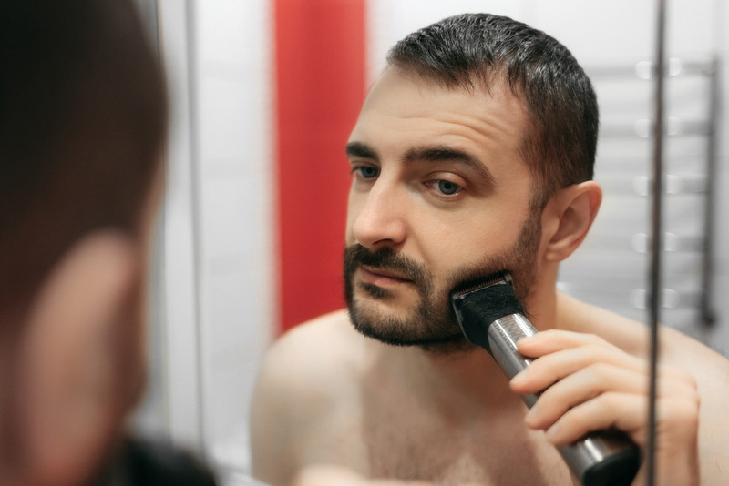 Man grooming beard at home