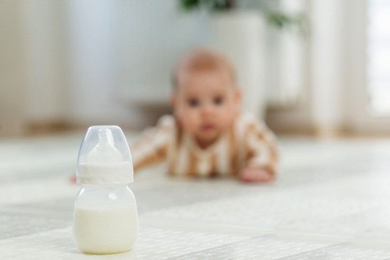 Baby crawling toward bottle