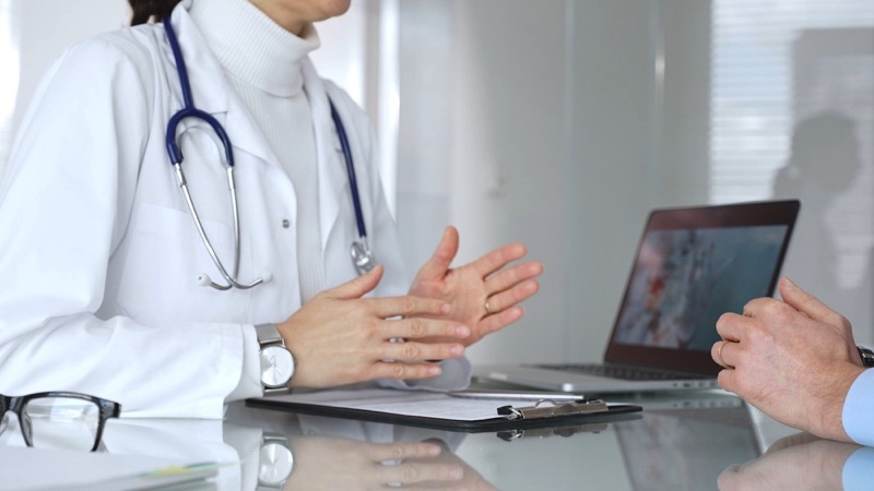 Man a doctor's office chatting with a doctor