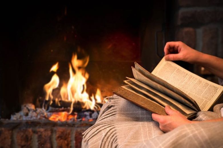 Reading a book by a fireplace